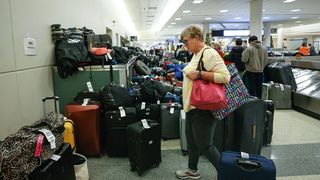 A stranded Southwest Airlines passenger searches for luggage in the baggage claim area of ​​Chicago Midway International Airport in Chicago, Illinois, December 28, 202.